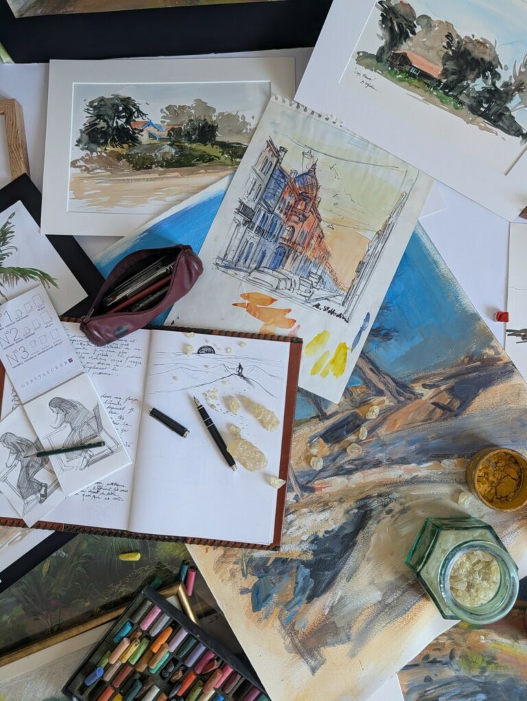 Matériel varié de dessin et peinture : aquarelles, croquis au crayon, carnets et résine pour préparations artisanales.
