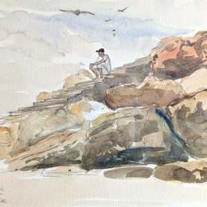 Carnet de voyage au Maroc. Un homme en djellaba regarde la côte depuis le rocher du Diable.