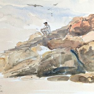 Carnet de voyage au Maroc. Un homme en djellaba regarde la côte depuis le rocher du Diable.